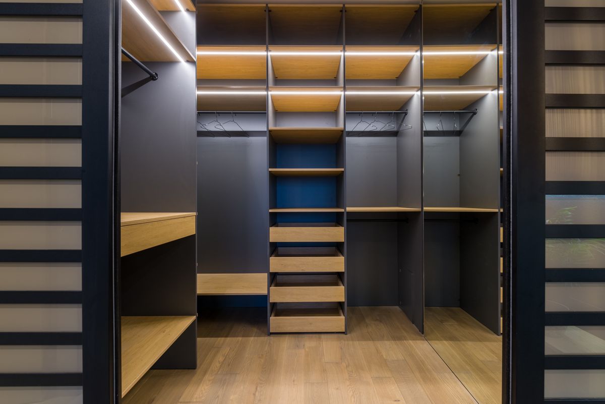Closet planejado em madeira com iluminação embutida